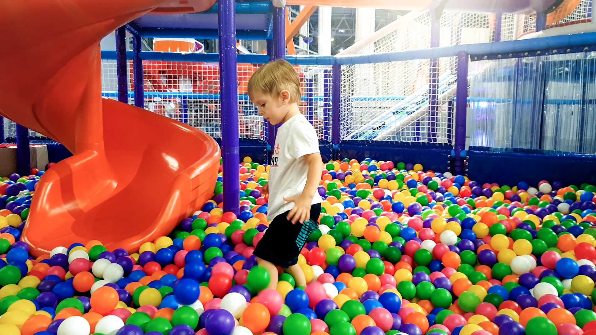 Bambino nella piscina di palline colorate